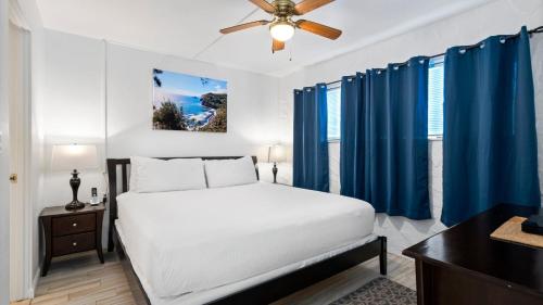 1 dormitorio con 1 cama y cortinas azules en Casa de Emdeko 121, en Kailua-Kona