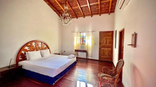 Un dormitorio con una cama grande y una lámpara de araña. en Miss Margrits en Granada