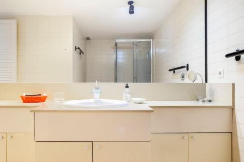 a white bathroom with a sink and a mirror at Comodidad y elegancia a lado de la Diagonal in Barcelona