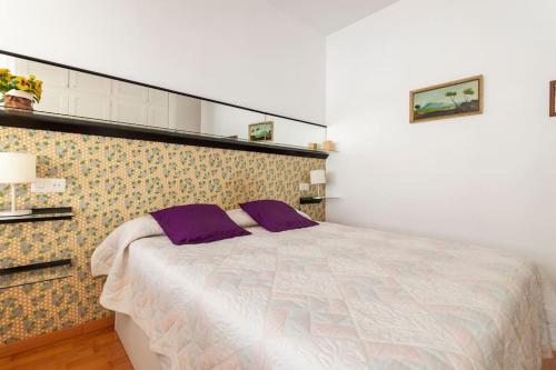 a bedroom with a large bed with purple pillows at Comodidad y elegancia a lado de la Diagonal in Barcelona
