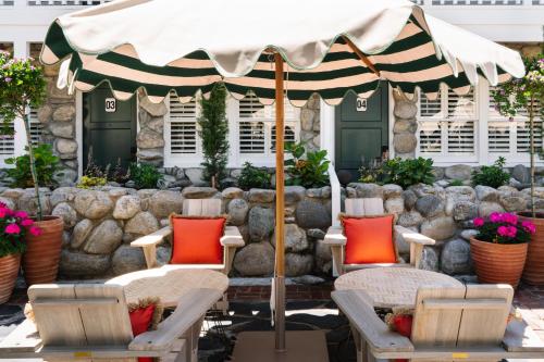 a group of chairs and an umbrella on a patio at Le Petit Pali at 8th Ave in Carmel
