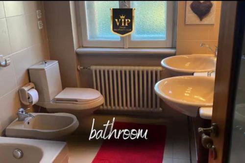 baño con aseo, 2 lavabos y ventana en Charming 2 bedrooms apartment, en Stabio