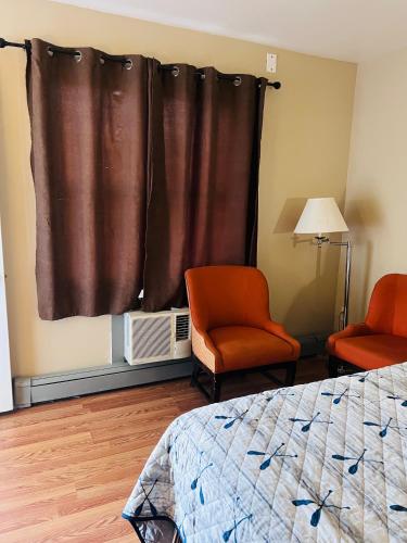 ナイアガラ・フォールズにあるRest and Relaxのベッドルーム1室(ベッド1台、椅子2脚、窓付)