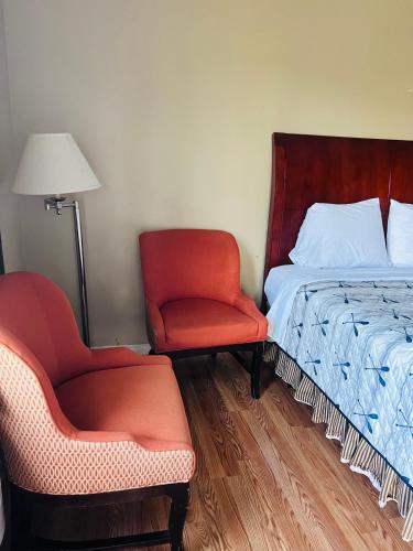 ナイアガラ・フォールズにあるRest and Relaxのベッドルーム1室(ベッド1台、椅子2脚、ベッド1台付)