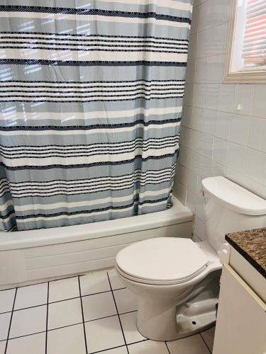 a bathroom with a toilet and a shower curtain at Rest and Relax in Niagara Falls