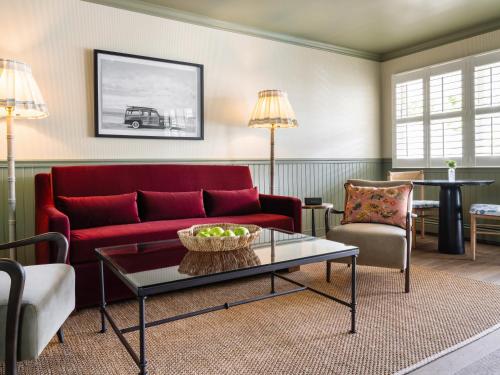 a living room with a red couch and a table at Le Petit Pali at 8th Ave in Carmel