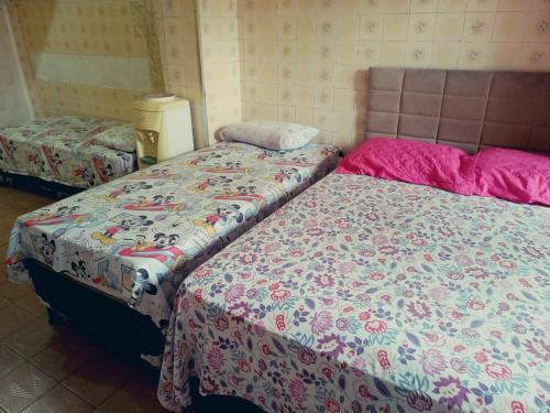 two beds sitting next to each other in a room at Kitnet Mobiliada in São Luís