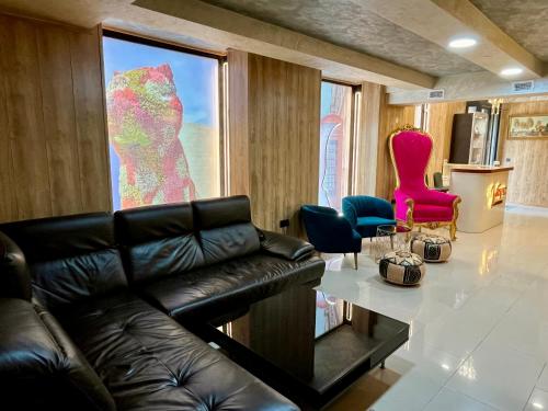 a living room with a black leather couch and a large window at Velvet Hostels in Madrid