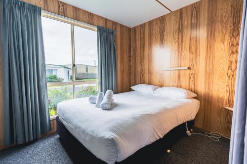 a bedroom with a large bed with a large window at BIG4 Stanley Holiday Park in Stanley