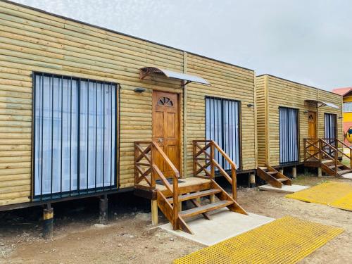 a row of wooden buildings with a wooden door at Cabañas EMC in Los Vilos