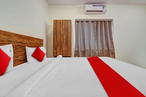 una camera da letto con un grande letto bianco con cuscini rossi di OYO Flagship 81135 Hotel R Square Inn a Hyderabad