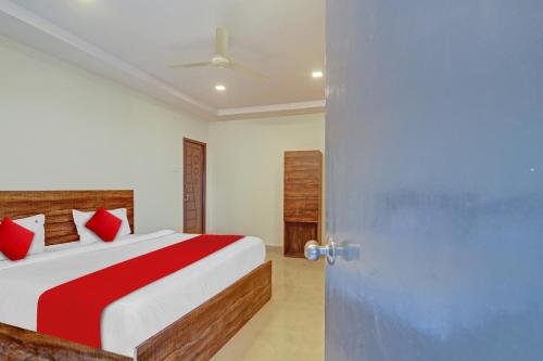 a bedroom with a bed with red pillows and a door at OYO Flagship 81135 Hotel R Square Inn in Hyderabad