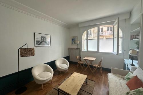 un salon avec un canapé, des chaises et une table dans l'établissement Beautiful bright studio - close to the Seine, à Paris