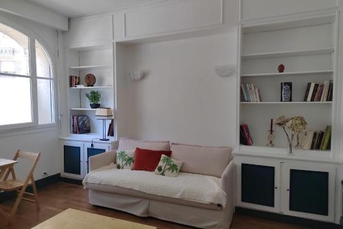 - un salon avec un canapé et quelques étagères dans l'établissement Beautiful bright studio - close to the Seine, à Paris