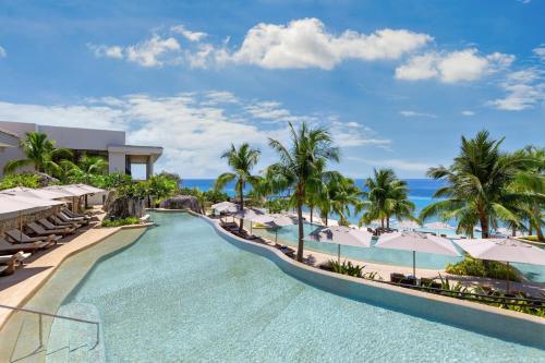 an infinity pool at a resort with palm trees and the ocean at Sheraton Cebu Mactan Resort in Mactan