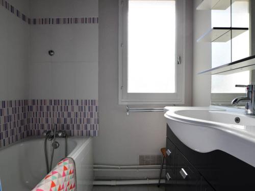 La salle de bains blanche est pourvue d'un lavabo et d'une baignoire. dans l'établissement Maison 3 pièces à La Palmyre, proche mer, patio et parking, 4 pers. - FR-1-705-47, aux Mathes