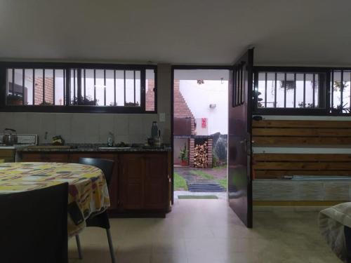 uma cozinha com uma mesa e uma porta que conduz a um quintal em Casa Pampa em Alta Gracia