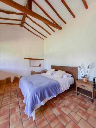 a bedroom with a large bed and a wooden ceiling at Trinitarios in Barichara