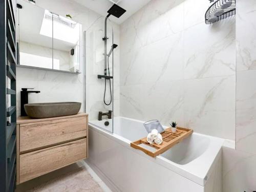 uma casa de banho com um lavatório e uma banheira e um lavatório em London's Charm Modern 2BR Marylebone's Best Spot em Londres