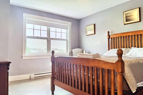 um quarto com uma cama de madeira e uma janela em Coco home em Charlottetown