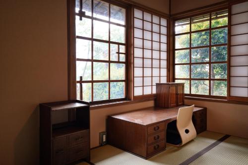 an office with windows and a desk and a chair at new! 熱海桃山邸　Atami terrace villa 〜Sauna & Onsen 〜 in Atami