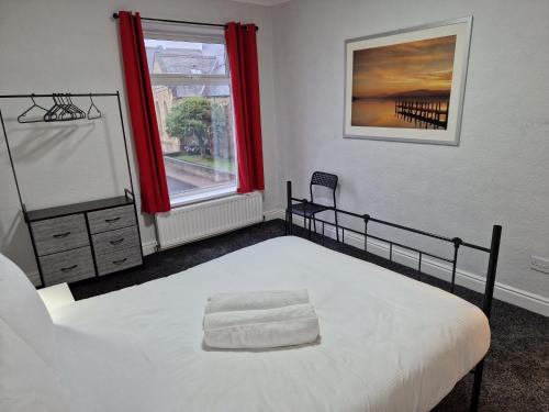 a bedroom with a bed and a window with red curtains at Birtley's Diamond 3 bed Apt, sleeps 6 Guests in Birtley