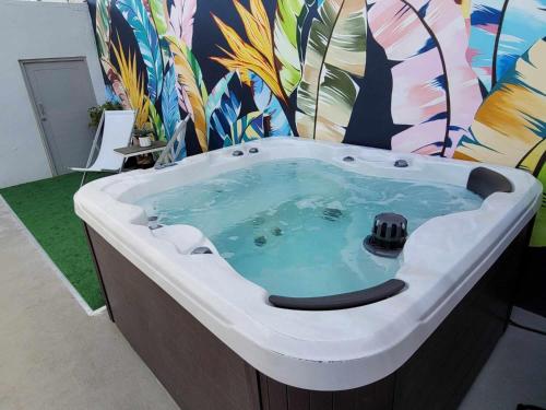 eine Whirlpool-Badewanne in einem Zimmer mit Wandgemälde in der Unterkunft Casa Aroma Di Caffee in Yauco