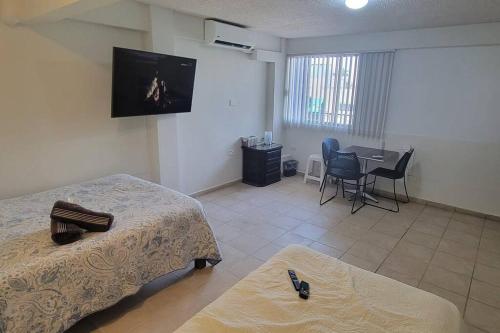 Habitación con 2 camas y mesa con sillas. en Departamento ( j ) Comodo centrico Tv Ac wifi cocina parking, en Ciudad Valles