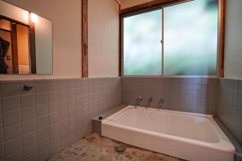 een badkamer met een bad en een raam bij new! 熱海桃山邸　Atami terrace villa 〜Sauna & Onsen 〜 in Atami
