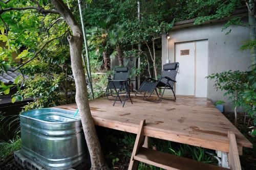 a wooden deck with chairs and a tree at new! 熱海桃山邸　Atami terrace villa 〜Sauna & Onsen 〜 in Atami