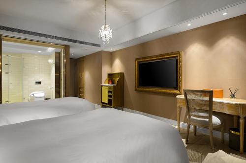 a hotel room with a bed and a television at 格拉斯行館 Grasse Grace Manor 苗栗唯一SLH會員 in Nanzhuang