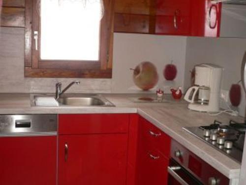 a kitchen with red cabinets and a sink at Chalet cosy avec piscine privée au Val-d'Ajol, 3 chambres - FR-1-589-597 in Le Val-dʼAjol