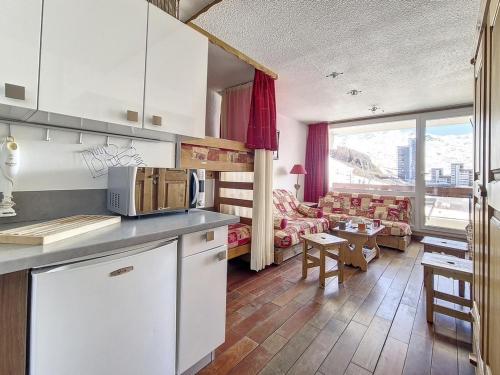 une cuisine avec des armoires blanches et un salon dans l'établissement Studio lumineux, ski aux pieds, balcon sud, 24 m², 4 pers, 2 flocons argent - La Croisette, Les Belleville - FR-1-344-1180, aux Menuires