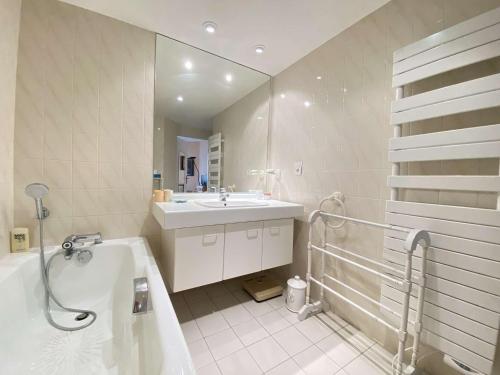 une salle de bain avec une baignoire et un lavabo et une baignoire dans l'établissement Appartement T4 calme avec terrasse à La Baule, proche plage Benoît - FR-1-245-192, au Pouliguen