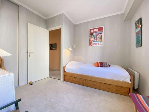 une chambre avec un lit et un panneau sur le mur dans l'établissement Appartement T4 calme avec terrasse à La Baule, proche plage Benoît - FR-1-245-192, au Pouliguen