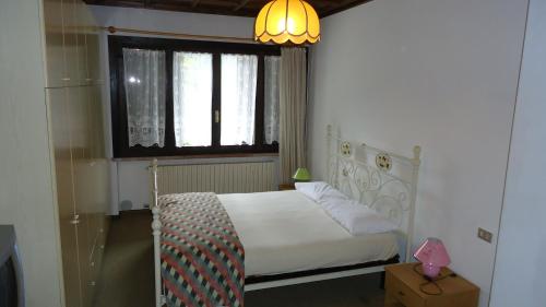 a bedroom with a white bed and a window at Residence Regina Delle Dolomiti in Rocca Pietore