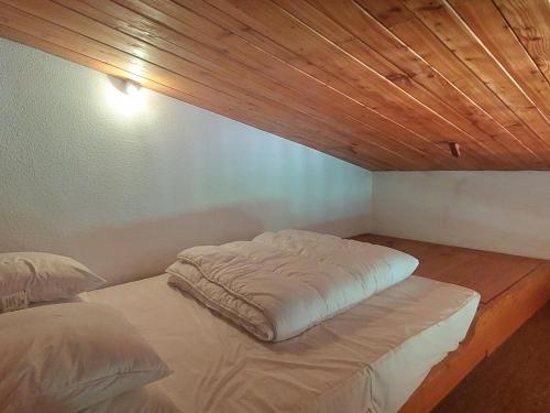 a bed in a room with a wooden ceiling at Appartement spacieux et rénové - Ski aux pieds - Balcon - Wifi - 8/9 pers - FR-1-346-553 in Arc 1800