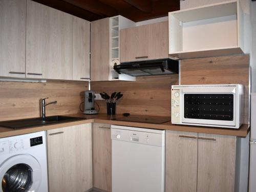 une cuisine avec un micro-ondes et un lave-linge et un sèche-linge dans l'établissement Appartement 3 Pièces avec Mezzanine, Balcon Sud, Parking et Cave - Centre Ville Proche Commodités - FR-1-580-92, à Font-Romeu-Odeillo-Via
