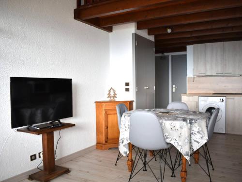 - une cuisine avec une table et une télévision dans la chambre dans l'établissement Appartement 3 Pièces avec Mezzanine, Balcon Sud, Parking et Cave - Centre Ville Proche Commodités - FR-1-580-92, à Font-Romeu-Odeillo-Via