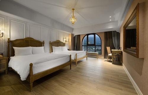 een slaapkamer met 2 bedden en een groot raam bij 格拉斯行館 Grasse Grace Manor in Nanzhuang