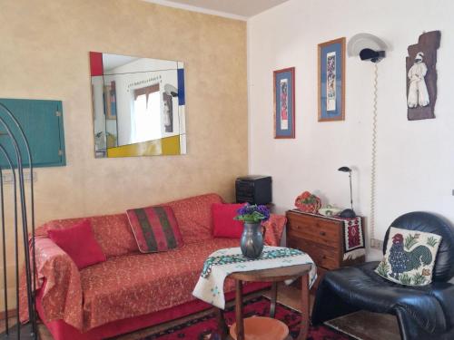 een woonkamer met een rode bank en een spiegel bij Holiday home dei Pavoni, Montemaggiore in Montemaggiore al Metauro