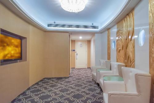 a waiting room with white chairs and a chandelier at Nanjing Central Hotel in Nanjing