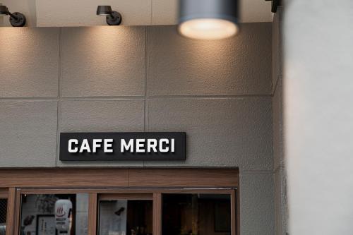 a sign that says cafe merci on a building at Hotel Arthur KITAHAMA BASE in Beppu