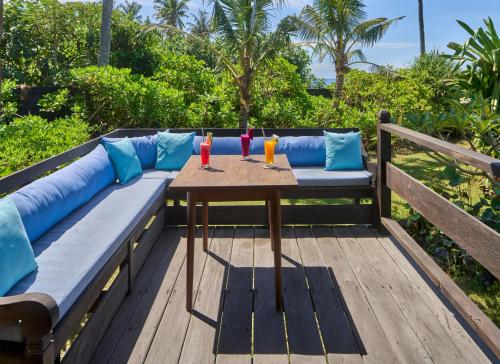 a wooden bench with a table and drinks on it at Jasri Bay Hideaway in Jasri