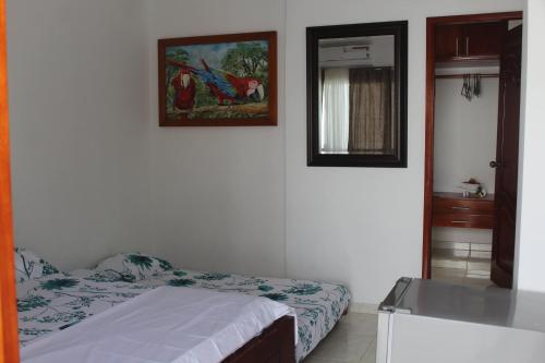 a bedroom with a bed and a picture on the wall at CASAS BLANCAS Coveñas in Coveñas