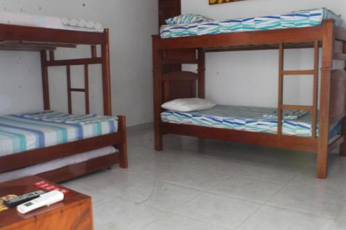 a room with three bunk beds and a table at CASAS BLANCAS Coveñas in Coveñas