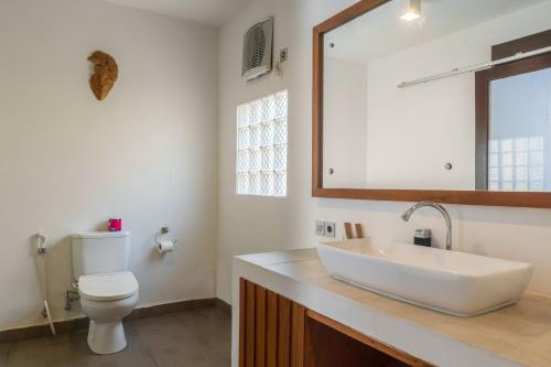 a bathroom with a white sink and a toilet at Gili Khayangan Villas in Gili Trawangan