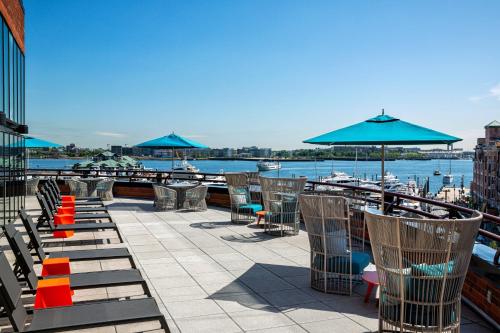 a patio with chairs and umbrellas next to the water at Boston Marriott Long Wharf in Boston