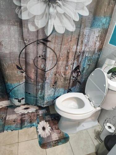 a bathroom with a toilet and a flower mural at Beautiful home near mall & beach in St. Petersburg