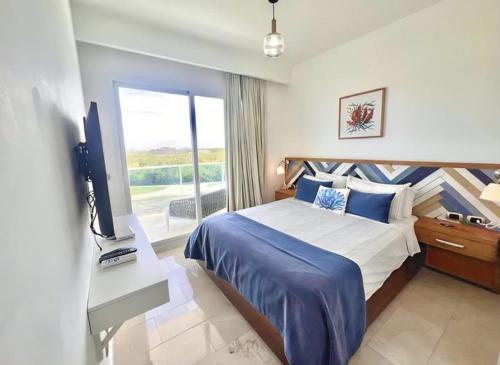 een slaapkamer met een bed, een tv en een raam bij Hard Rock at Cana Rock 2 by Unwind Properties in Punta Cana